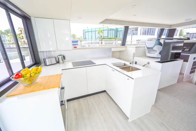  Yacht Photos Pics Modern kitchen interior on 2022 Sunpower 44 VIP yacht, featuring sleek white cabinetry and appliances.