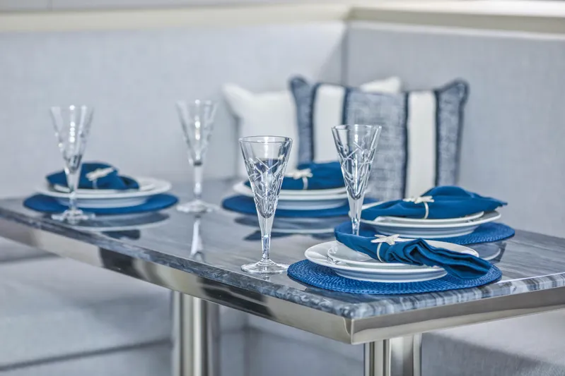  Yacht Photos Pics Elegant dining setup on Sunpower 44 VIP yacht, featuring blue accents and crystal glassware, 2022 model.