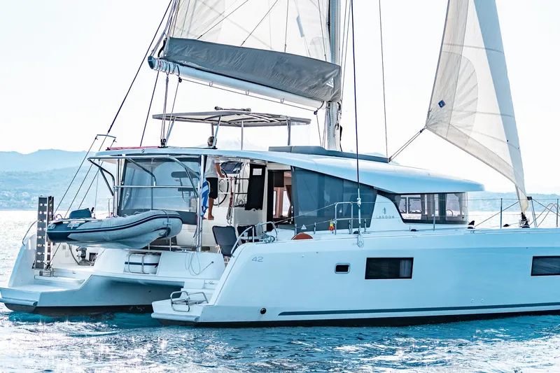  Yacht Photos Pics 2018 Lagoon 42 catamaran sailing on calm waters with raised sails.