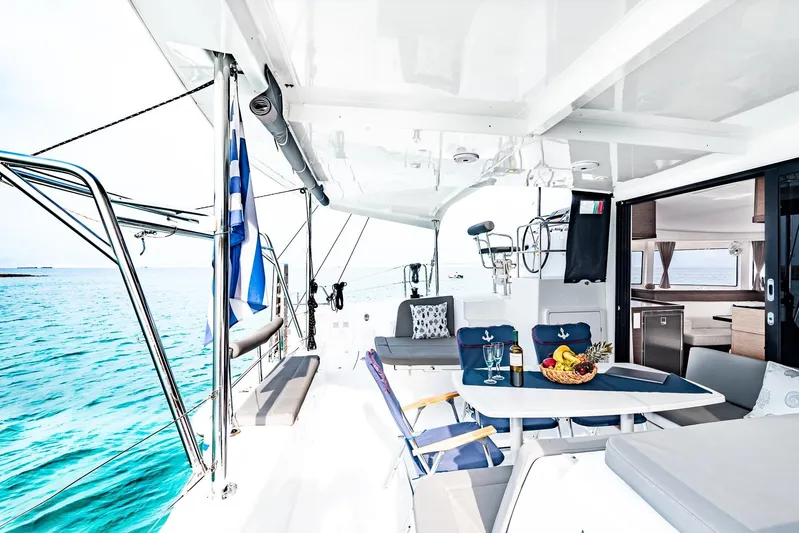  Yacht Photos Pics Luxurious 2018 Lagoon 42 yacht deck with dining area, overlooking turquoise sea.