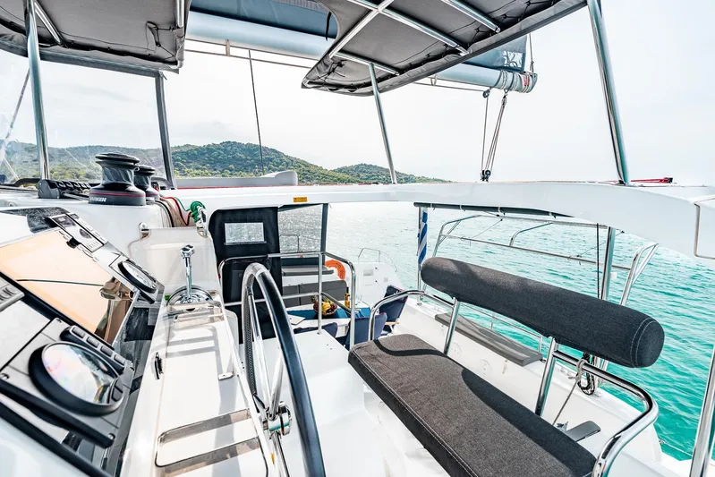  Yacht Photos Pics 2018 Lagoon 42 yacht cockpit with modern navigation equipment and seating, overlooking serene waters.
