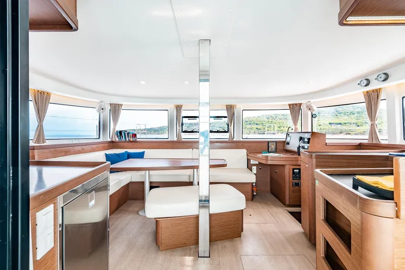  Yacht Photos Pics Spacious interior of 2018 Lagoon 42 catamaran with modern furnishings and panoramic windows.
