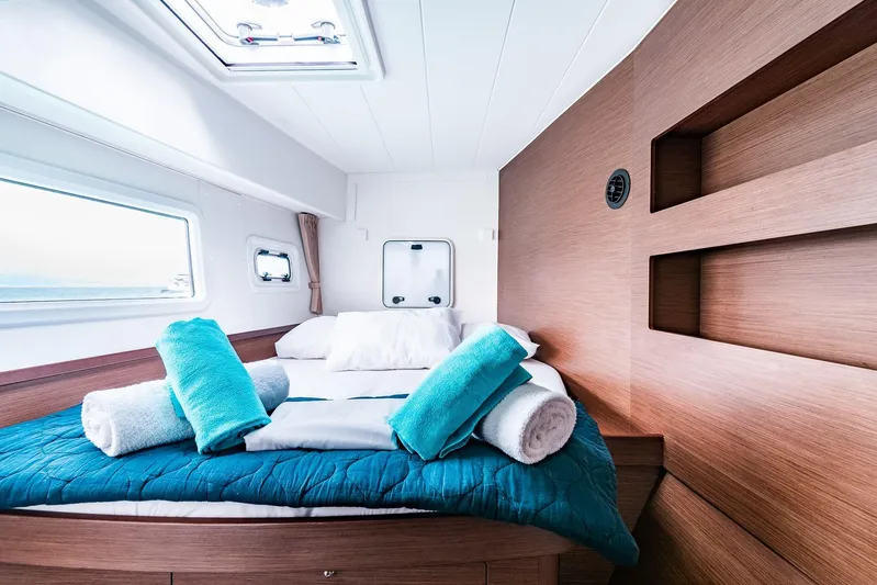  Yacht Photos Pics Luxurious cabin interior of 2018 Lagoon 42 catamaran with cozy bedding and natural light.