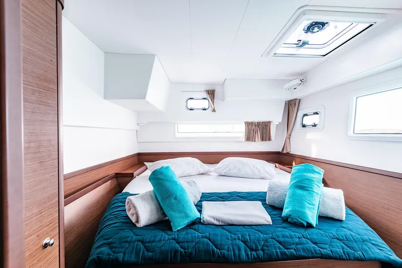  Yacht Photos Pics Luxurious cabin interior of 2018 Lagoon 42 catamaran with cozy bedding and natural light.