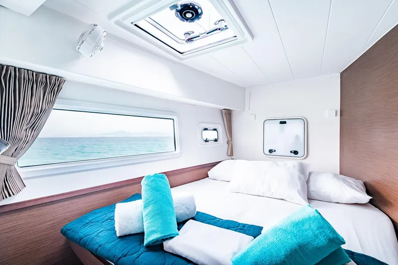  Yacht Photos Pics Luxurious cabin interior of 2018 Lagoon 42 catamaran with ocean view and cozy bedding.