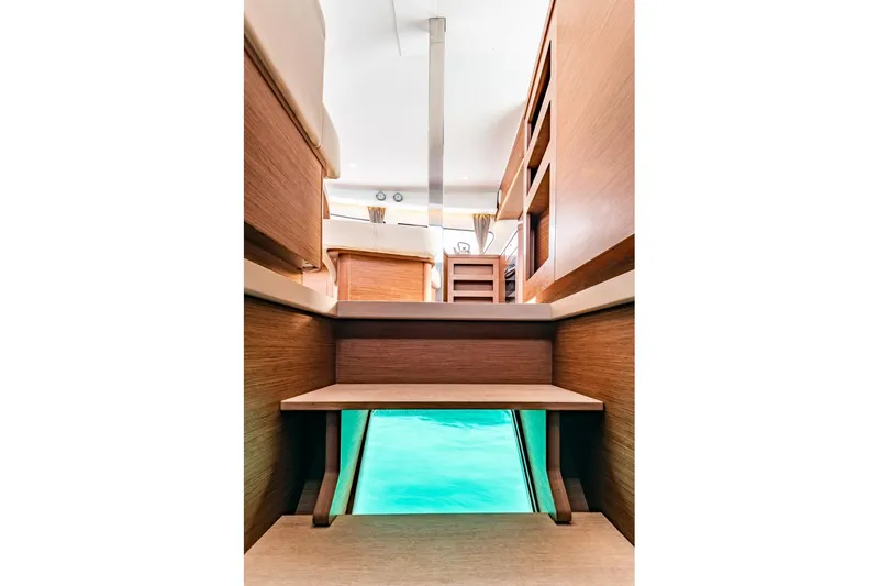  Yacht Photos Pics Interior view of 2018 Lagoon 42 catamaran with wooden steps and turquoise water below.