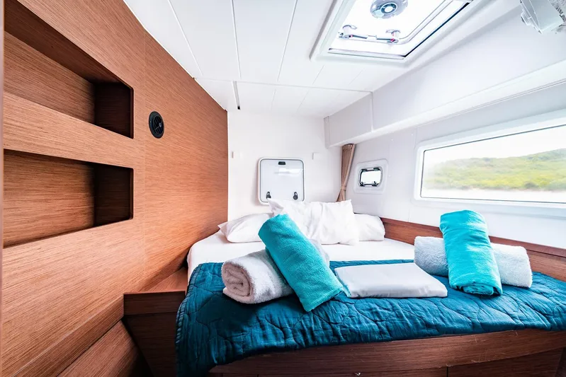 Yacht Photos Pics Luxurious cabin interior of 2018 Lagoon 42 catamaran with cozy bedding and natural light.