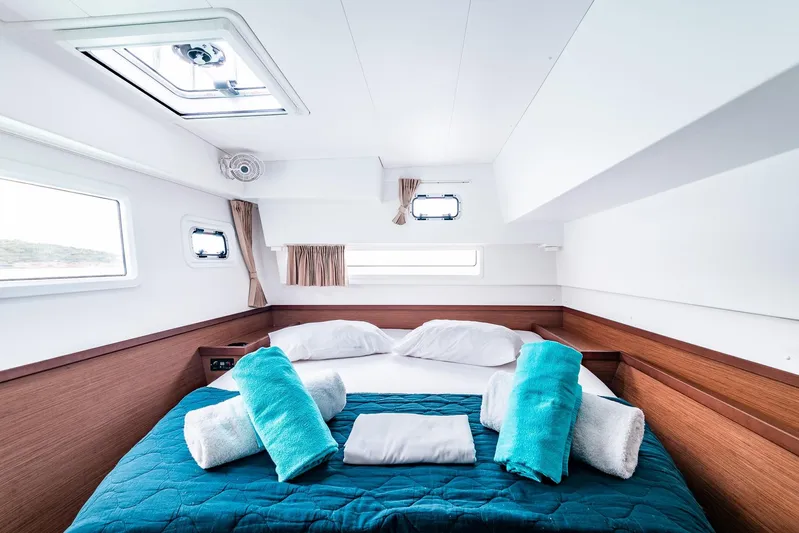  Yacht Photos Pics Luxurious cabin interior of 2018 Lagoon 42 catamaran with cozy bed and plush towels.