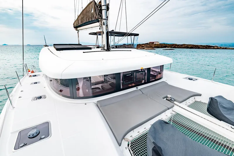  Yacht Photos Pics 2018 Lagoon 42 catamaran on tranquil sea, showcasing spacious deck and modern design.