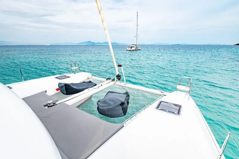  Yacht Photos Pics 2018 Lagoon 42 catamaran on turquoise sea with distant sailboat.