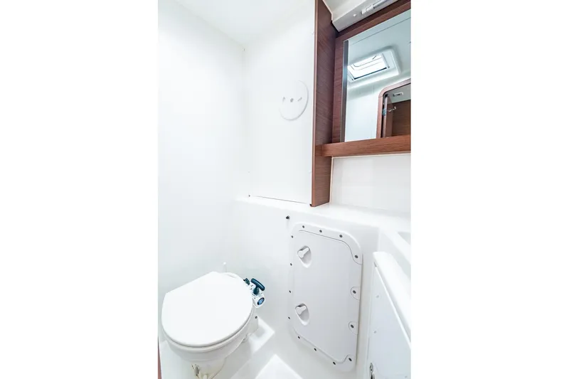  Yacht Photos Pics 2018 Lagoon 42 yacht bathroom with white fixtures and wooden accents.