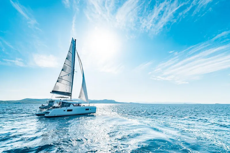  Yacht Photos Pics 2018 Lagoon 42 catamaran sailing on a sunny day with clear blue skies.