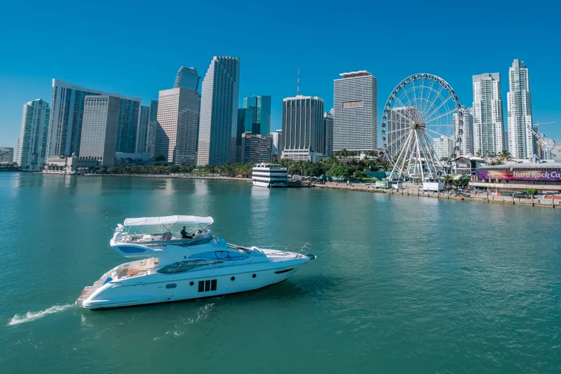Prime Time Yacht Photos Pics Azimut 48 Flybridge yacht cruising near city skyline and Ferris wheel, 2012 model.