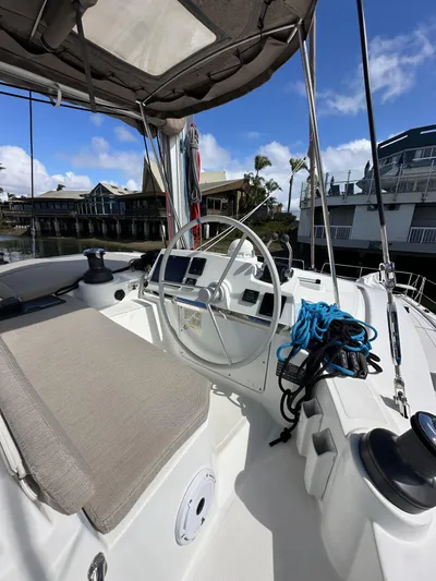 After You Yacht Photos Pics 2023 Bali 4.2 yacht cockpit with steering wheel, ropes, and seating, docked at marina.