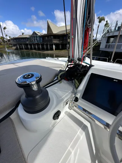 After You Yacht Photos Pics 2023 Bali 4.2 sailboat deck with winch and control panel, docked near waterfront buildings.