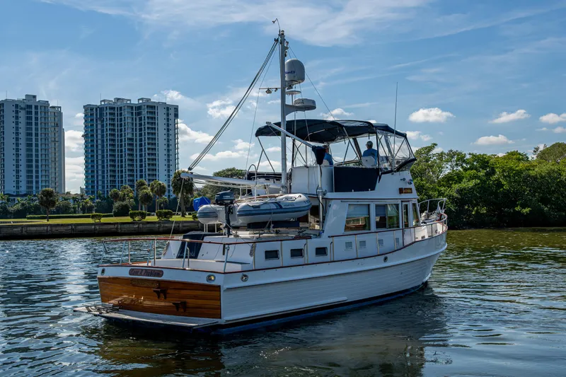  Yacht Photos Pics Grand Banks 42 Classic yacht, 2002 model, cruising on a sunny day near urban skyline.