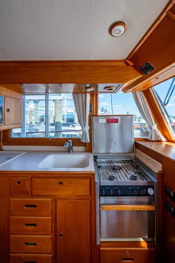  Yacht Photos Pics 2002 Grand Banks 42 Classic yacht kitchen with wooden cabinetry and stainless steel stove.
