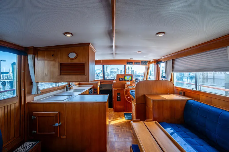  Yacht Photos Pics Interior of 2002 Grand Banks 42 Classic yacht with wooden cabinetry and blue seating.