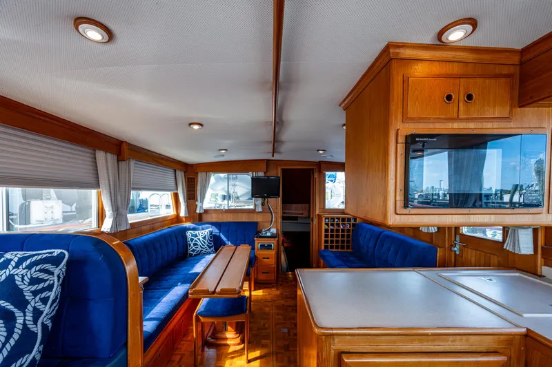  Yacht Photos Pics Interior of 2002 Grand Banks 42 Classic yacht with blue seating and wooden cabinetry.