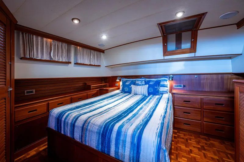  Yacht Photos Pics Luxurious cabin interior of 2002 Grand Banks 42 Classic yacht with wood finish and striped bedding.