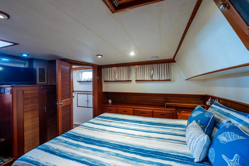  Yacht Photos Pics Luxurious cabin interior of 2002 Grand Banks 42 Classic yacht with striped bedding.