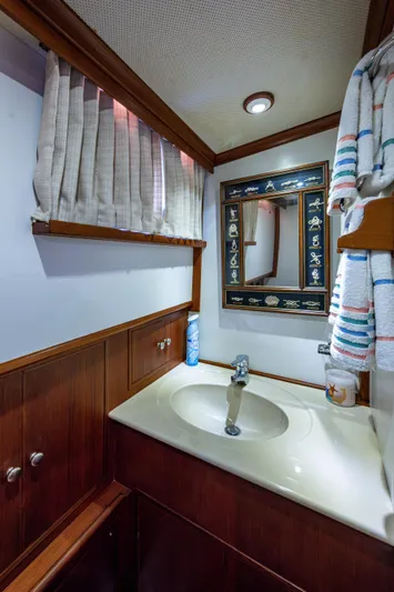  Yacht Photos Pics Bathroom interior of 2002 Grand Banks 42 Classic yacht with wooden cabinetry and mirror.