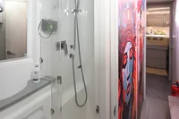 Interior of 2017 Leopard 51 Powercat featuring modern bathroom and vibrant wall art.
