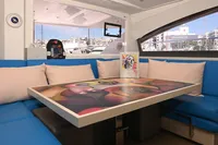 Interior of 2017 Leopard 51 Powercat with colorful table and blue seating.
