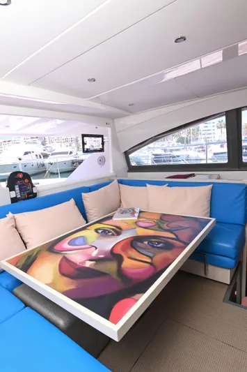  Yacht Photos Pics Interior of 2017 Leopard 51 Powercat with colorful table art and blue seating.