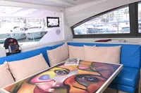 Interior of 2017 Leopard 51 Powercat with colorful table art and blue seating.