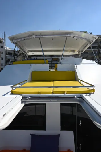  Yacht Photos Pics 2017 Leopard 51 Powercat with yellow sunbeds and canopy, docked under clear blue sky.