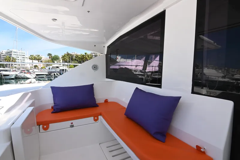  Yacht Photos Pics Leopard 51 Powercat 2017 yacht with orange seating and purple cushions in marina setting.