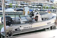 Highfield tender boat docked, featuring a steering wheel and Yamaha engine, near waterfront cafes.
