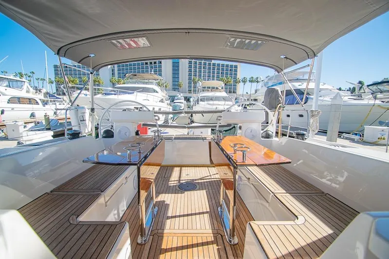  Yacht Photos Pics Spacious deck of 2021 Bavaria C45 yacht in marina, featuring elegant wood finish and seating.