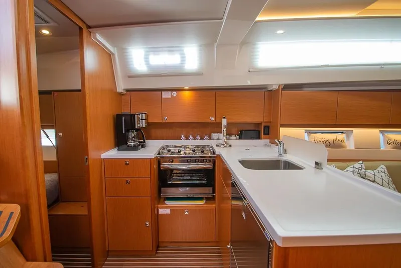  Yacht Photos Pics Modern kitchen interior of 2021 Bavaria C45 yacht with wooden cabinetry and sleek countertops.