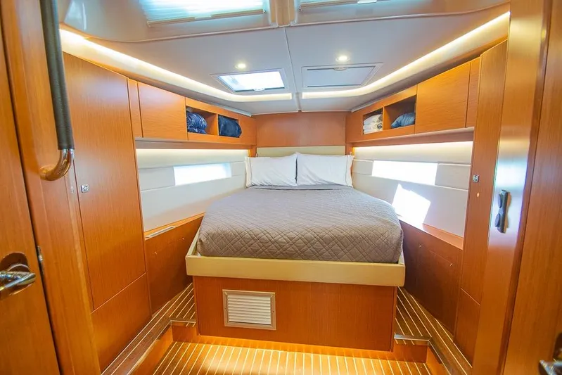  Yacht Photos Pics Luxurious cabin interior of 2021 Bavaria C45 yacht with cozy bed and wooden finish.