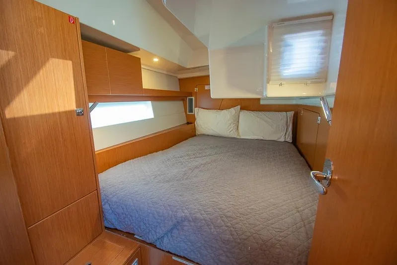  Yacht Photos Pics Cozy cabin interior of 2021 Bavaria C45 yacht with wooden finish and comfortable bedding.