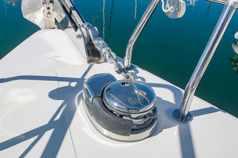  Yacht Photos Pics Anchor chain mechanism on 2021 Bavaria C45 yacht, reflecting sunlight on calm water.