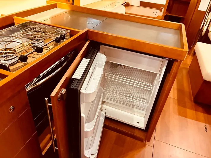  Yacht Photos Pics Interior of 2017 Beneteau Oceanis 45 yacht kitchen with open fridge and stove.