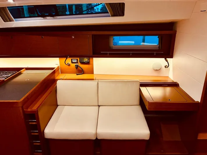  Yacht Photos Pics Interior of 2017 Beneteau Oceanis 45 yacht with cozy seating and elegant wood finish.