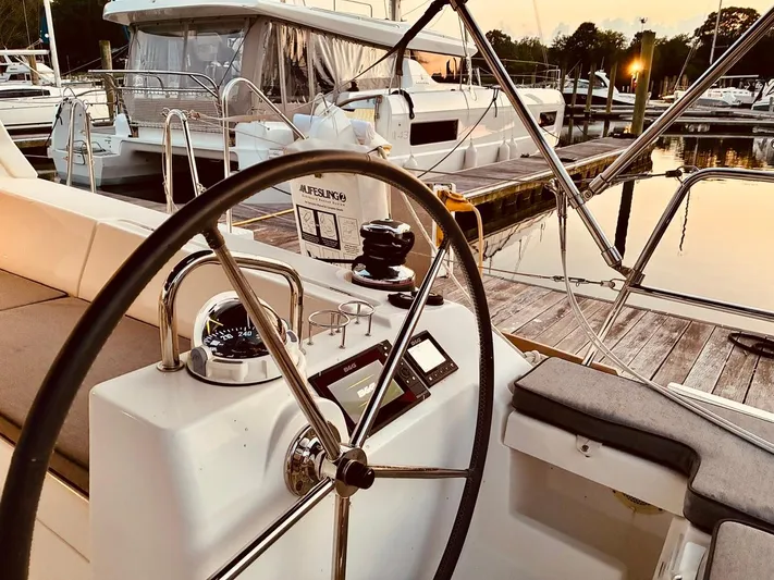  Yacht Photos Pics Cockpit view of a 2017 Beneteau Oceanis 45 yacht at sunset in a marina.