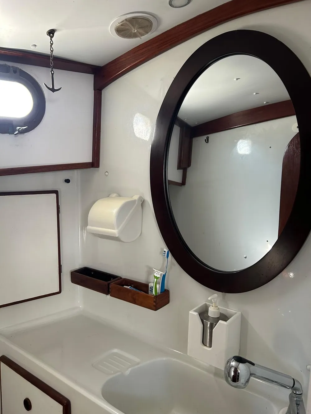 Vintage 1975 Salar 40 yacht bathroom with oval mirror and wooden accents.