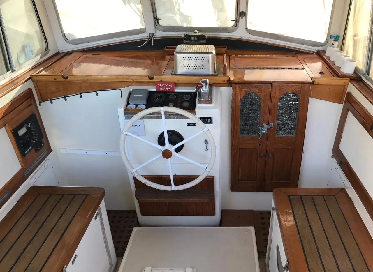 Interior of a 1975 Salar 40 boat, featuring a wooden helm and seating.