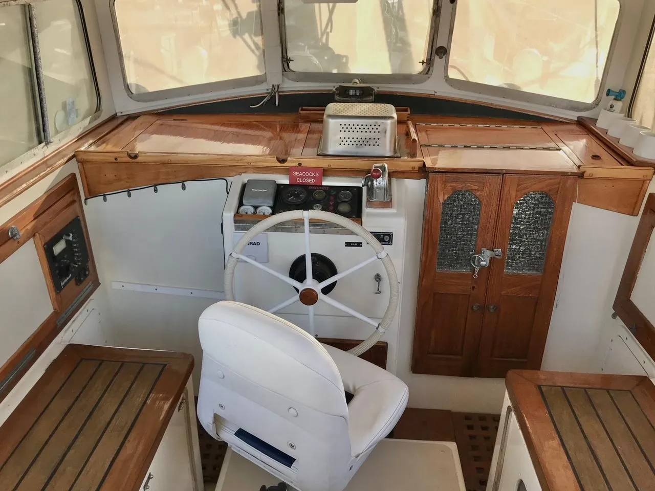 Interior of a 1975 Salar 40 boat cockpit with wooden accents and steering wheel.