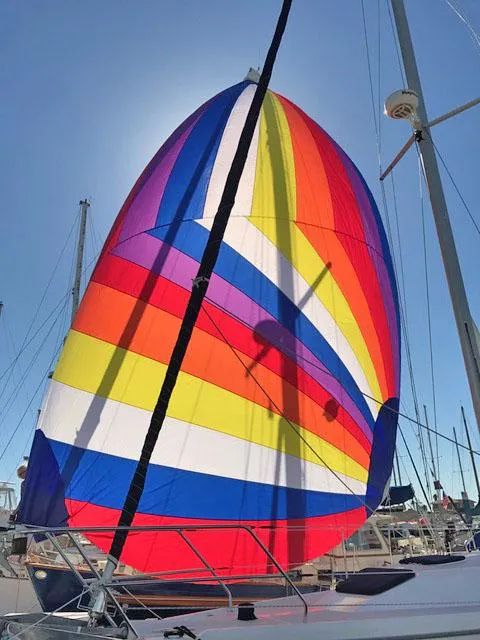 Colorful spinnaker sail on a 1975 Salar 40 yacht against a clear blue sky.