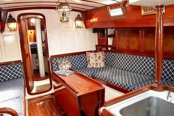 Victoria Yacht Photos Pics Interior of 1983 Cherubini Schooner with polished wood and blue patterned seating.