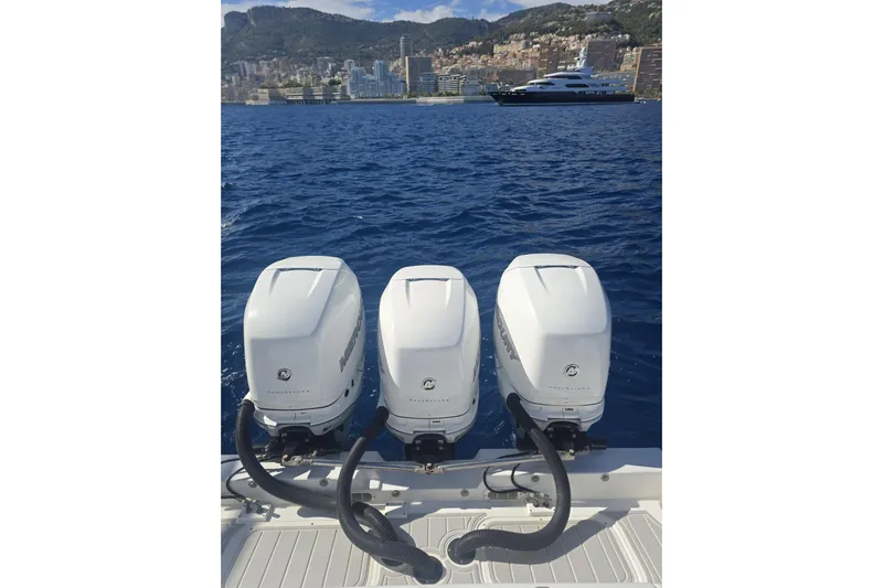 N/a Yacht Photos Pics Triple Mercury outboard engines on a 2014 Midnight Express 37 EXK boat, with scenic coastal backdrop.