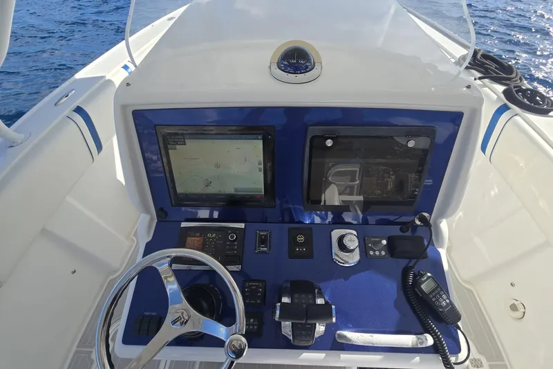 N/a Yacht Photos Pics Control panel of a 2014 Midnight Express 37 EXK boat with navigation screens and steering wheel.