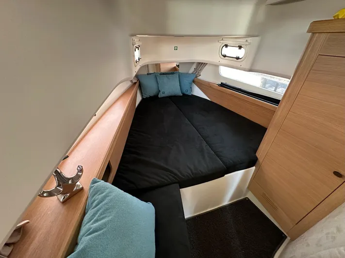 Mdr #187 In Stock Yacht Photos Pics Cozy cabin interior of 2023 Nimbus T11 with black bedding and wooden accents.