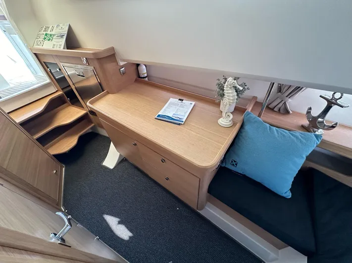 Mdr #187 In Stock Yacht Photos Pics Cozy interior of 2023 Nimbus T11 boat with wooden desk, blue cushion, and decorative items.